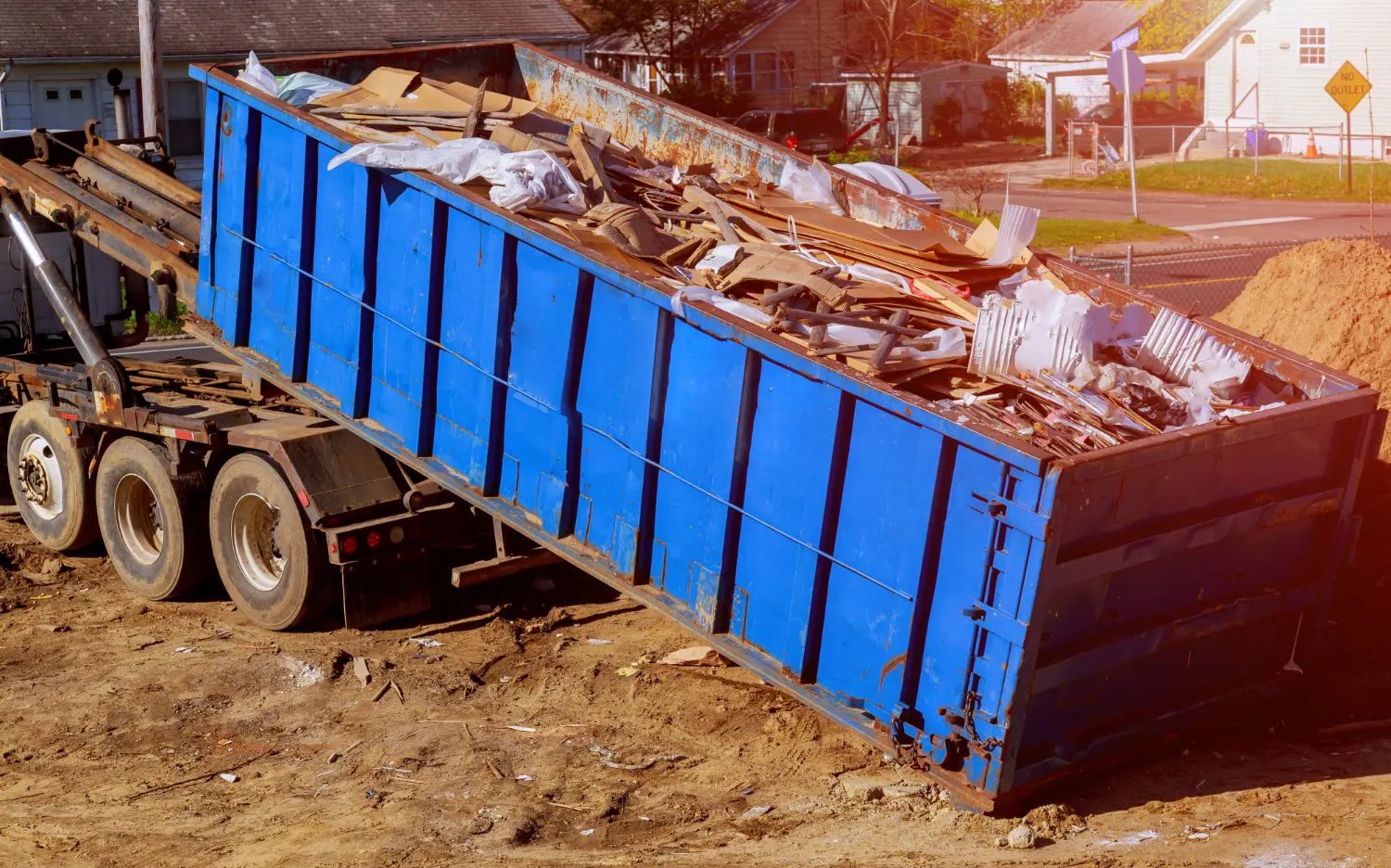 blue-construction-debris-container-filled-with-rock-concrete-rubble